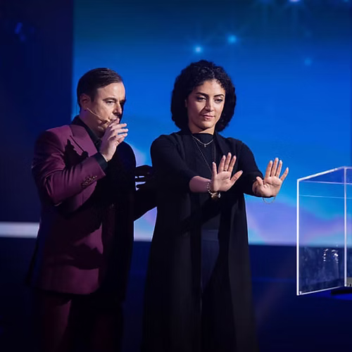 Professional magician performing on stage at a corporate event in Dubai